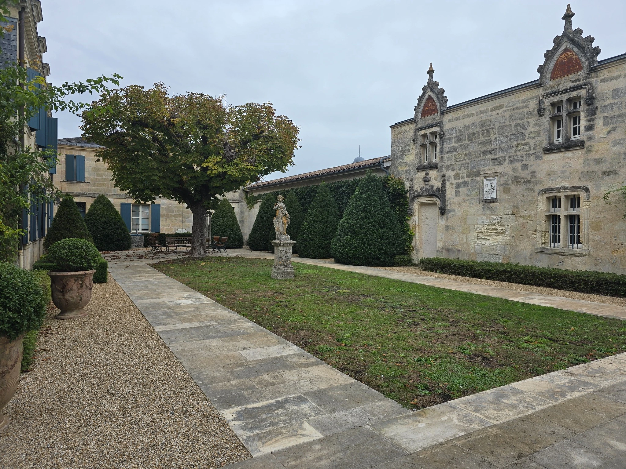 La corte di La Mission Haut-Brion con il giardino, la statua e gli edifici in pietra