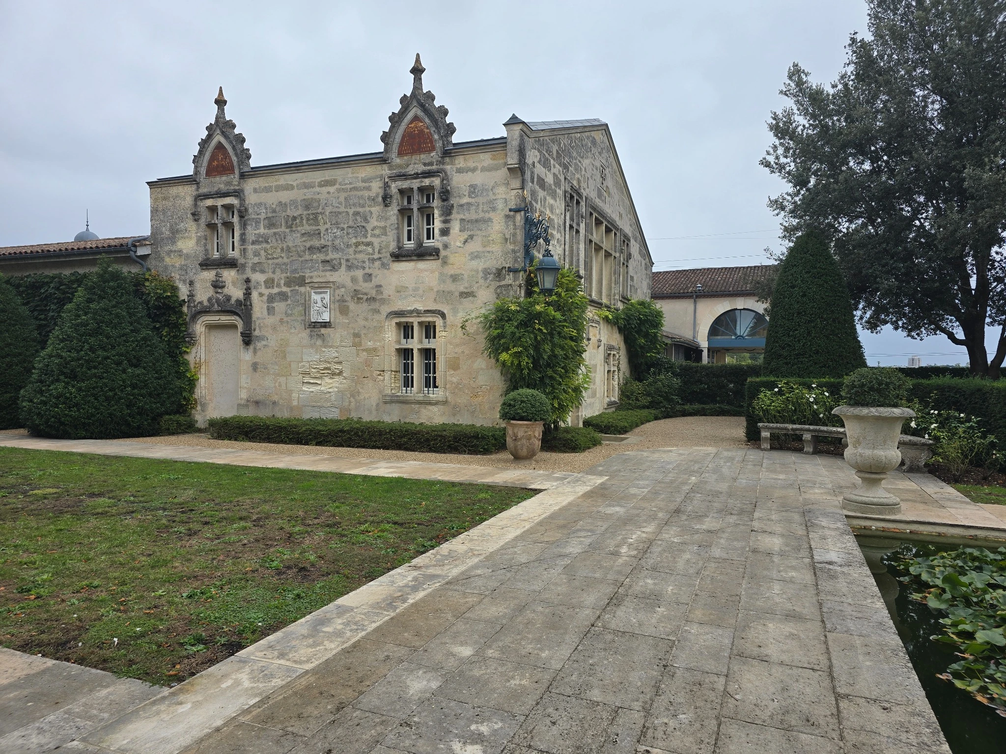 Facciata storica di La Mission Haut-Brion, lanterna in ferro e vasca del giardino