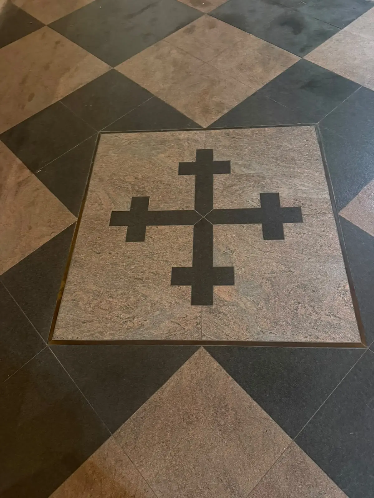 Emblema a croce inserito nel pavimento della cantina